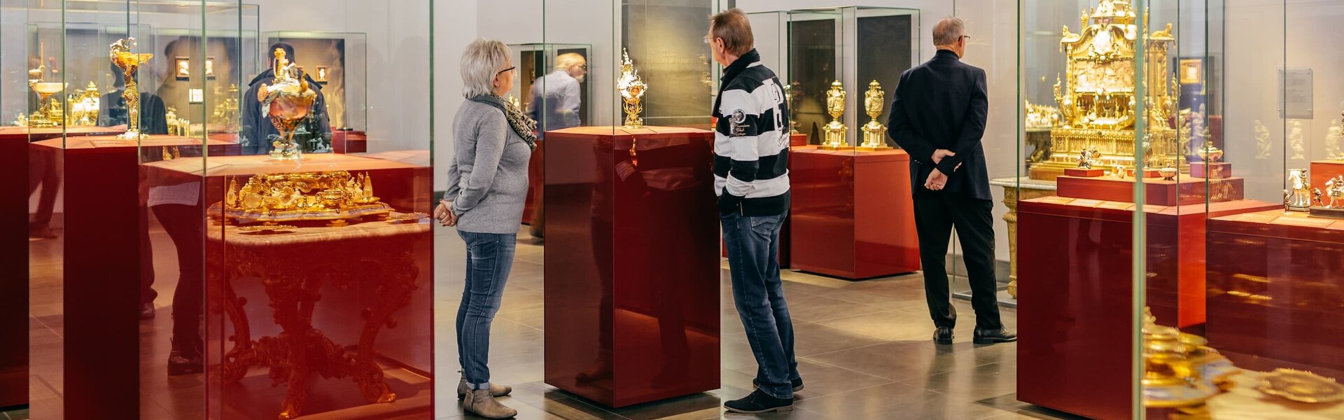 Neues Grünes Gewölbe im Residenzschloss Ausstellungsraum mit Vitrinen erkennbar, in welchen sich Ausstellungsstücke befinden, welche von einigen Personen betrachtet werden.